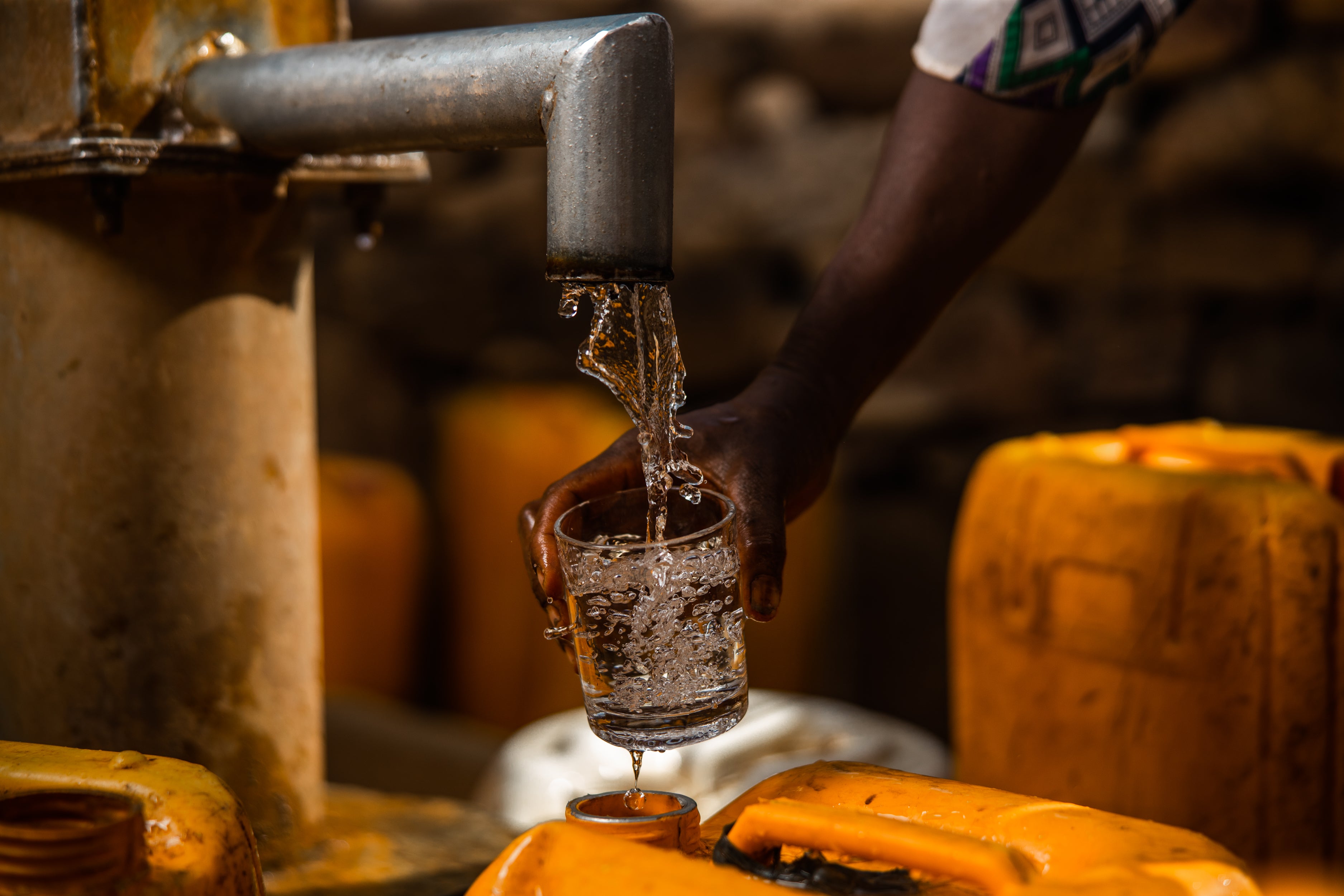 Person collecting water from water well